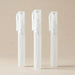 Three clear plastic bottles with caps on a beige background